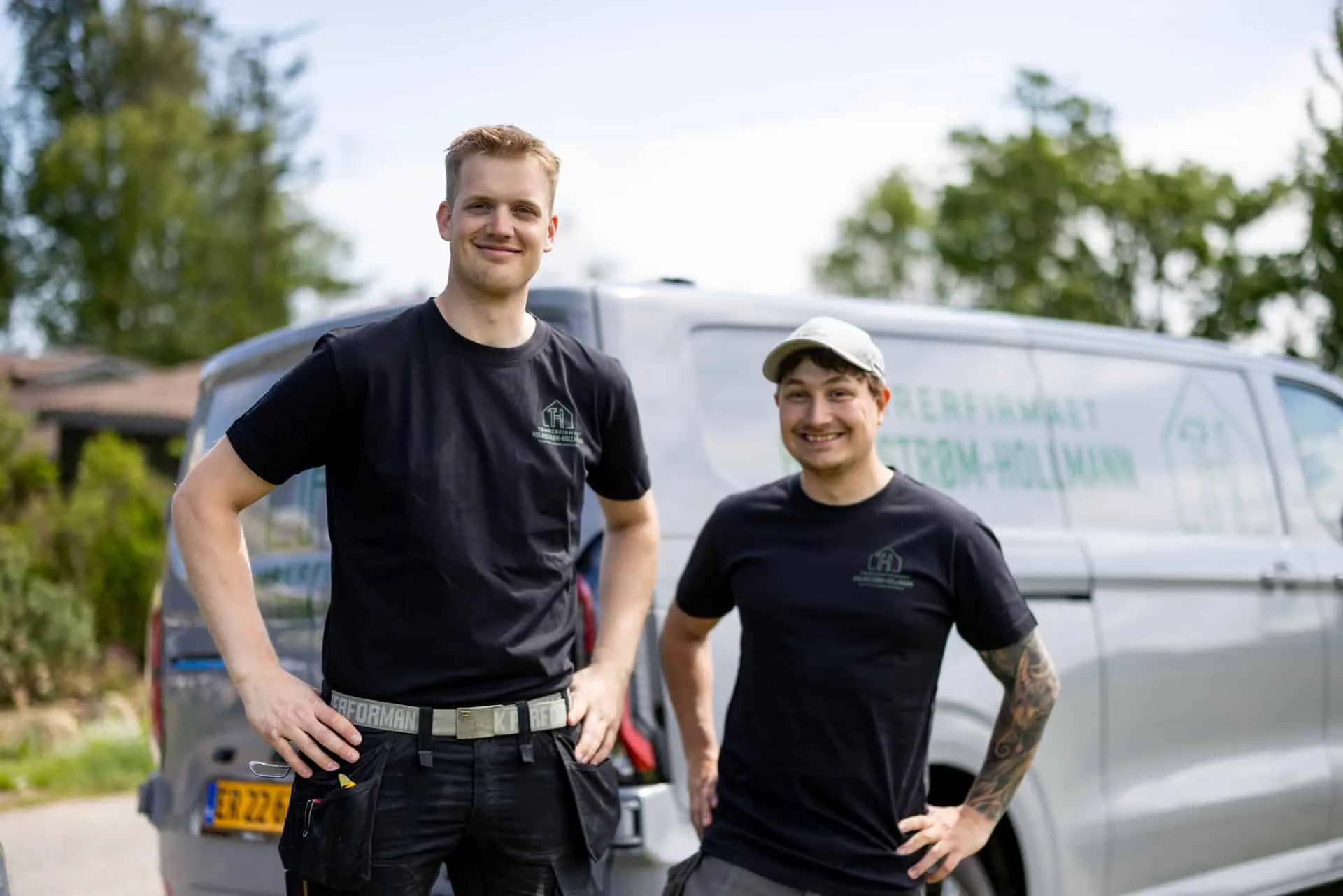To tømrere fra Tømrerfirmaet Holmstrøm-Hollmann foran firmabilen